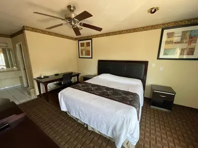 a hotel room with a bed and a ceiling fan at Hollywood Guest Inn in Los Angeles