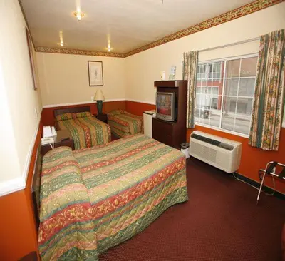 a hotel room with two beds and a television at Hollywood Guest Inn in Los Angeles