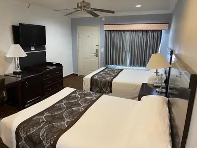 a hotel room with two beds and a flat screen tv at Hollywood Guest Inn in Los Angeles