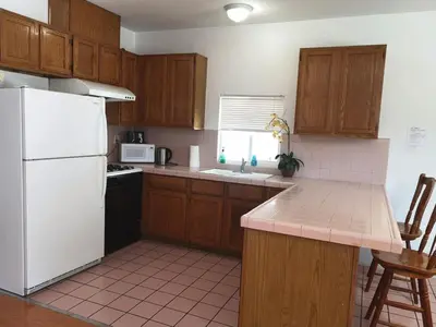 a kitchen with wooden cabinets and a white refrigerator at Pasadena single house 3b1b \u4e09\u623f\u4e00\u5385\u4e00\u53a8\u4e00\u6d74 in Pasadena