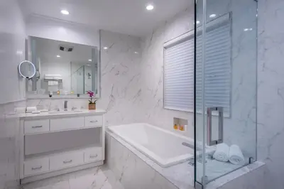a bathroom with a tub and a sink and a shower at Beverly Hills Plaza Hotel & Spa in Los Angeles