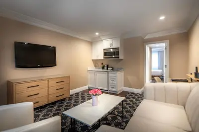 a living room with a couch and a tv at Beverly Hills Plaza Hotel & Spa in Los Angeles