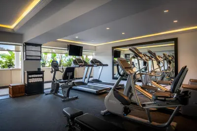 a gym with cardio machines and a large mirror at Beverly Hills Plaza Hotel & Spa in Los Angeles