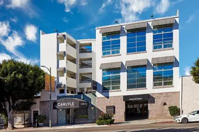 a building with a car parked in front of it at Carlyle Inn in Los Angeles