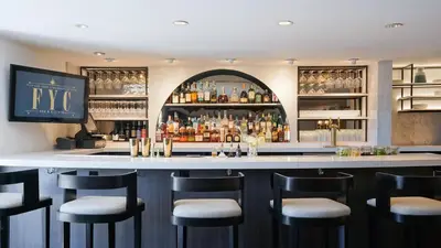a bar with stools in front of a bar at Hotel Amarano Burbank-Hollywood in Burbank