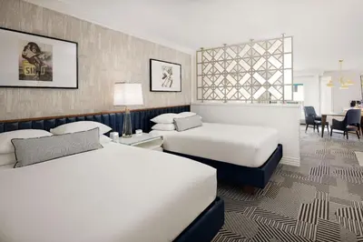 a hotel room with two beds and a table at Le Parc at Melrose in Los Angeles
