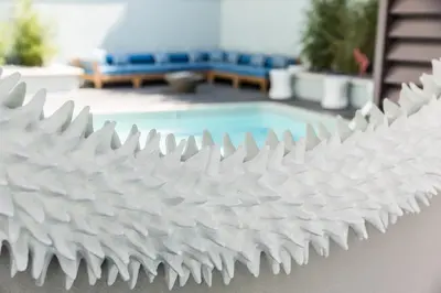 a white metal fence next to a swimming pool at Mosaic Hotel Beverly Hills in Los Angeles