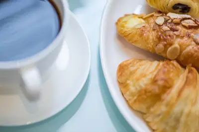 a plate of pastries next to a cup of coffee at Mosaic Hotel Beverly Hills in Los Angeles