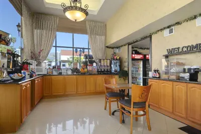a restaurant with a counter and a table and chairs at Ramada by Wyndham Pasadena in Pasadena