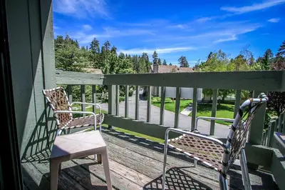 two chairs sitting on a porch with a fence at Boulder Creek-1412 by Big Bear Vacations in Big Bear Lake