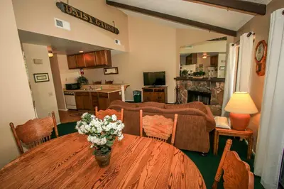 a living room with a wooden table with flowers on it at Boulder Creek-1412 by Big Bear Vacations in Big Bear Lake