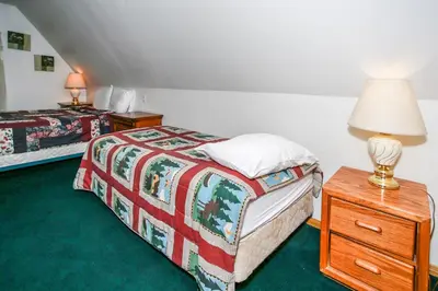 a bedroom with two beds and a lamp on a nightstand at Breezy Estate-114 by Big Bear Vacations in Big Bear Lake