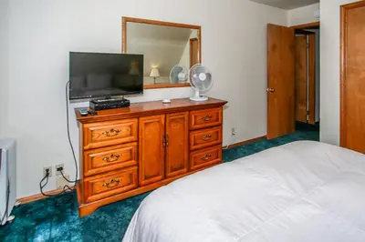 a bedroom with a television on a dresser with a bed at Breezy One-112 by Big Bear Vacations in Big Bear Lake