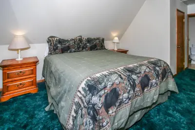 a bedroom with a bed and a night stand with two lamps at Breezy One-112 by Big Bear Vacations in Big Bear Lake