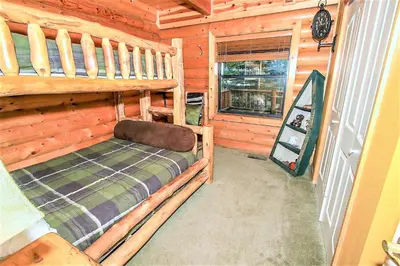 a bedroom with a bunk bed in a log cabin at Knotty and Nice-177 by Big Bear Vacations in Big Bear Lake
