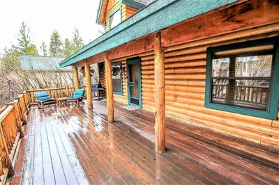 a wooden porch of a cabin with chairs on it at Knotty and Nice-177 by Big Bear Vacations in Big Bear Lake