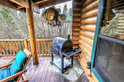 a grill on a screened in porch of a cabin at Knotty and Nice-177 by Big Bear Vacations in Big Bear Lake