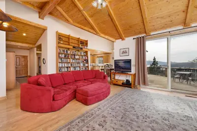 a living room with a red couch and a large window at Starlight Vistas-1524 by Big Bear Vacations in Big Bear Lake