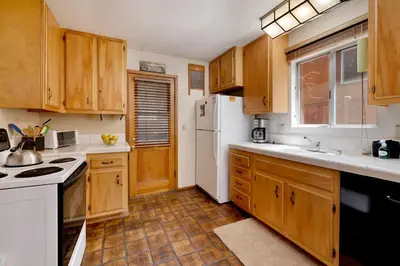 a kitchen with wooden cabinets and a white refrigerator at Popko's Place Resort Chalet by Big Bear Vacations in Big Bear Lake