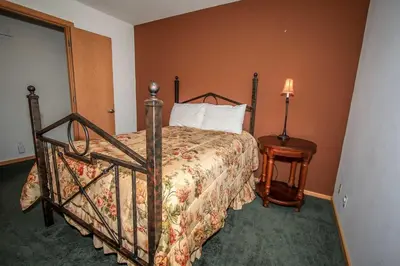 a bedroom with a bed and a table with a lamp at Can't Bear to Leave-1156 by Big Bear Vacations in Big Bear Lake