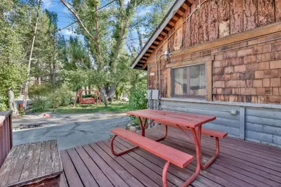 a red picnic table and a bench on a deck at Shore Acres Lodge-451 by Big Bear Vacations in Big Bear Lake