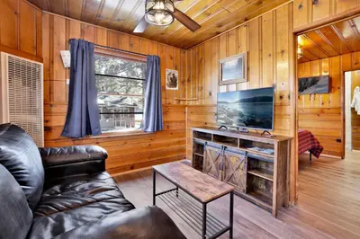 a living room with a leather couch and a television at Shore Acres Lodge-450 by Big Bear Vacations in Big Bear Lake