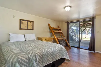 a bedroom with a bed and a sliding glass door at Lake Shore Family Cabin w Hot Tub and Pool Table by Big Bear Vacations in Big Bear Lake