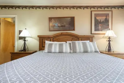 a bedroom with a large bed with two lamps at Lake Shore Family Cabin w Hot Tub and Pool Table by Big Bear Vacations in Big Bear Lake