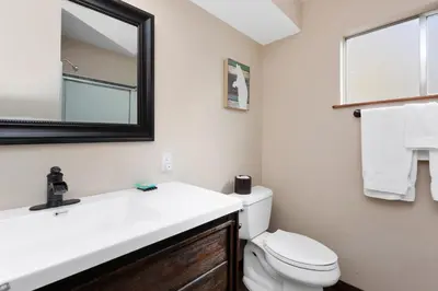 a bathroom with a sink and a toilet and a mirror at Mountain Fun-1729 by Big Bear Vacations in Big Bear Lake