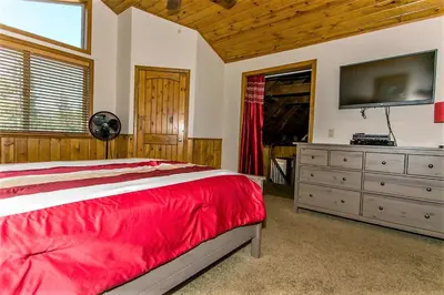 a bedroom with a bed and a flat screen tv at Grandpas Axe-1775 by Big Bear Vacations in Big Bear Lake