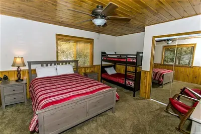 a bedroom with two bunk beds and a ceiling fan at Grandpas Axe-1775 by Big Bear Vacations in Big Bear Lake