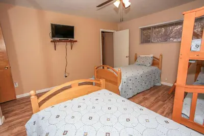 a bedroom with two bunk beds and a tv at Cozy up to Summit-1651 by Big Bear Vacations in Big Bear Lake