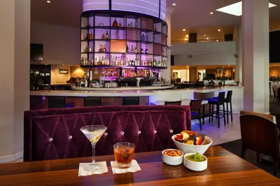 a bar in a restaurant with a table with a drink at Sheraton Gateway Los Angeles Hotel in Los Angeles