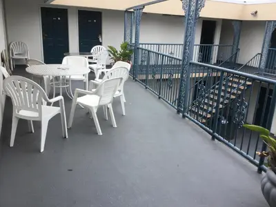 a balcony with white chairs and tables on a building at Beverly Inn in Los Angeles