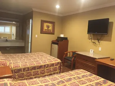 a hotel room with two beds and a flat screen tv at Beverly Inn in Los Angeles