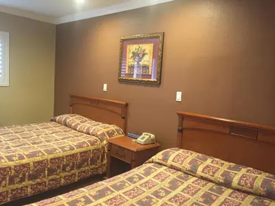 a hotel room with two beds and a picture on the wall at Beverly Inn in Los Angeles