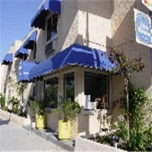 a building with a blue umbrella on the side of it at Beverly Inn in Los Angeles