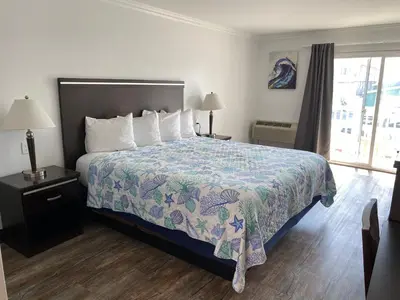 a hotel room with a bed and a window at Ocean Surf Inn & Suites in Huntington Beach
