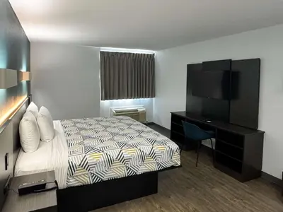 a hotel room with a bed and a desk and a television at Motel 6-Carson, CA in Carson