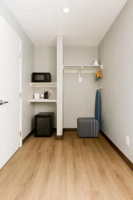 an empty living room with a table and a chair at Travelodge by Wyndham LAX in El Segundo