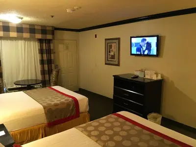 a hotel room with two beds and a flat screen tv at Ramada by Wyndham Ontario Airport & Convention Center in Ontario