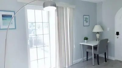 a white room with a desk and a window with a lamp at Pasadena suite with private entrance in Pasadena