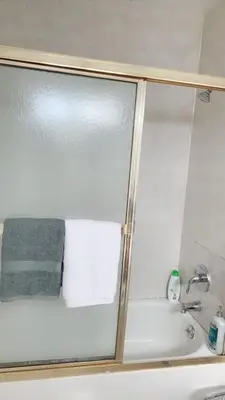 a shower with a glass door next to a sink at Pasadena suite with private entrance in Pasadena