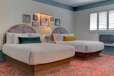 a bedroom with two beds and a fireplace at The Hollywood Franklin Hotel near Universal Studios in Los Angeles