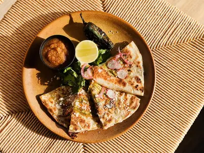 a plate of food with a pizza and a salad at Hotel June West LA, a Member of Design Hotels in Los Angeles
