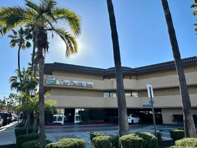 a hotel with palm trees in front of it at The Pacific Inn in Seal Beach