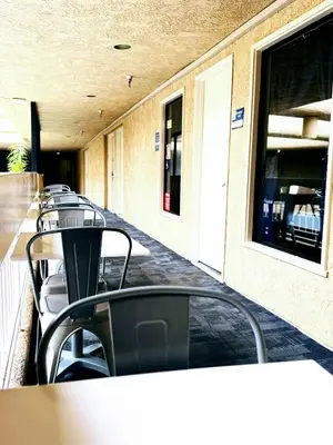 a row of tables and chairs in front of a building at The Pacific Inn in Seal Beach