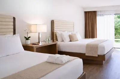 a hotel room with two beds and a window at Luxe Sunset Boulevard Hotel in Los Angeles
