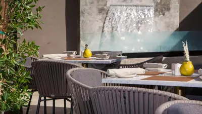 a dining room with tables and chairs and a window at Luxe Sunset Boulevard Hotel in Los Angeles