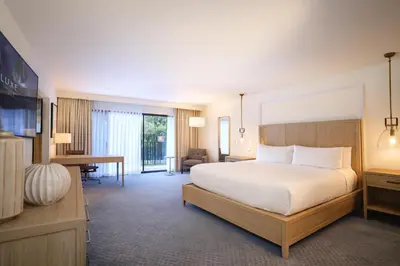 a bedroom with a large white bed and a desk at Luxe Sunset Boulevard Hotel in Los Angeles